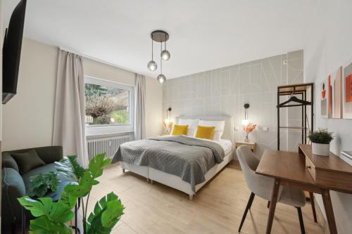 a bedroom with a bed and a desk at Modernes Design-Apartment am Drachenfels in Bad Honnef am Rhein