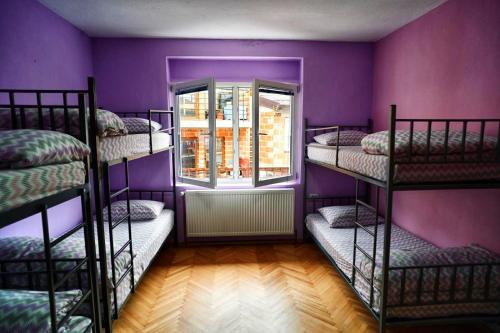 a room with three bunk beds with a window at Sunset Lake hostel in Ohrid