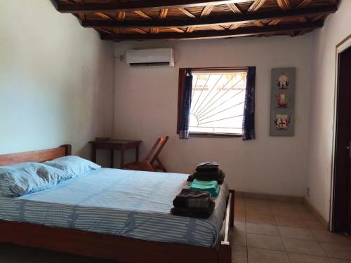 ein Schlafzimmer mit einem Bett und einem Fenster in der Unterkunft Baobab Beach Villa in Abémé