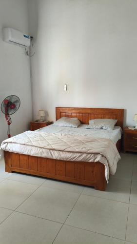 a bedroom with a wooden bed in a room at Baobab Beach Villa 2 in Abémé