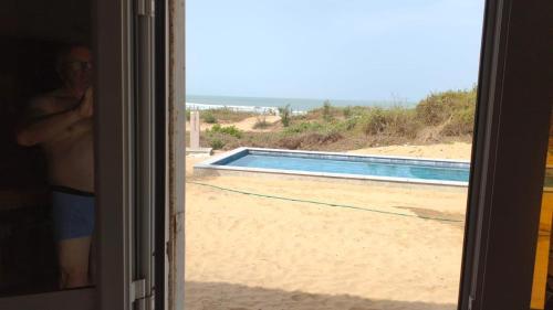 a view of a swimming pool from a window at Baobab Beach Villa 2 in Abémé