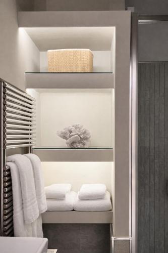 a bathroom with white towels on a shelf at MEDITERRANEAN SEASONS, VILLA MEDITERRANEA Taormina, Private Pool & Sea View in Taormina