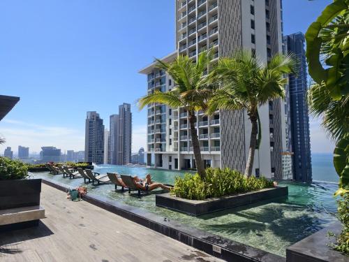 a view of the ocean from a resort with palm trees at 1 BR 5mins to beach Sea view Riviera Wongamat in North Pattaya