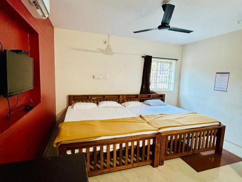 a bedroom with a bed and a flat screen tv at Comforts Bhairavi INN in Kalyānpur