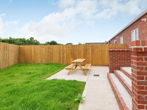 a picnic table in a backyard with a fence at Dawson Park 7 - Uk12666 in Mablethorpe