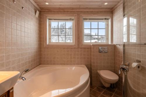 a bathroom with a tub and a toilet and a sink at Cosy and central Apartment in Holo