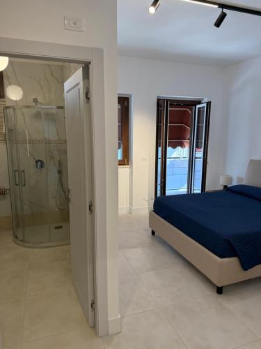 a bedroom with a blue bed and a shower at Suites Prestige in Peschici