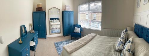 a blue bedroom with a bed and blue cabinets at By the Sea in Redcar