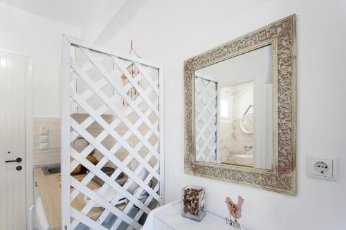 a mirror on a wall next to a staircase at Alexia Studios in Kolios