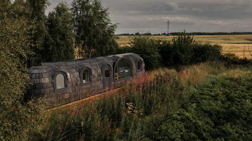 an old train sitting in the middle of a field at Boath Cabin in Auldearn