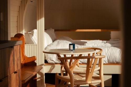 a table and two chairs in front of a bed at Boath Cabin in Auldearn