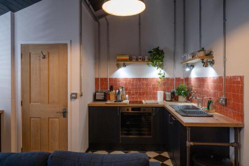 a kitchen with a counter and a table in a room at 2 The Old Canteen, Two Minute Walk To Beach in Lyme Regis