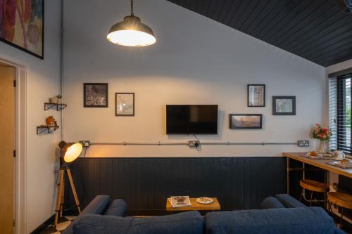 a living room with two blue chairs and a television at 2 The Old Canteen, Two Minute Walk To Beach in Lyme Regis
