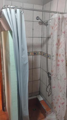 a shower with a shower curtain in a bathroom at Cabaña La Perla in Isla Negra