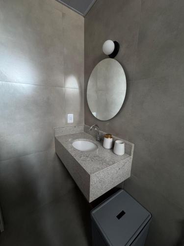 a bathroom with a sink and a mirror and a toilet at Apartamento no Umarizal in Belém
