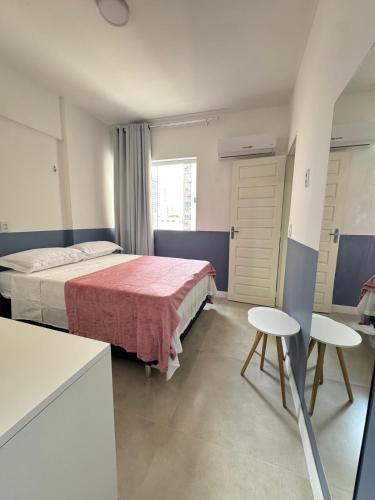 a bedroom with a bed and two chairs in it at Apartamento no Umarizal in Belém