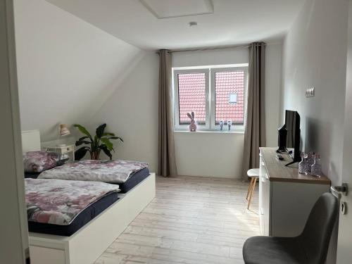 a bedroom with a bed and a desk with a computer at Haus Anna O in Westoverledingen