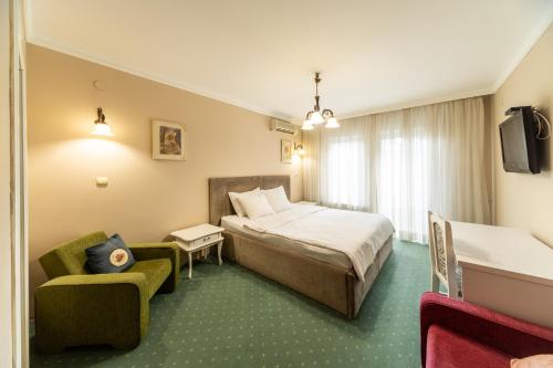 a hotel room with a bed and a chair at Garni Hotel President de Luxe in Kragujevac