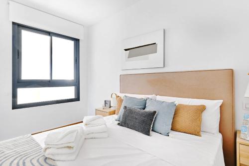 a white bedroom with a large white bed and a window at Velapi 23 in Roda