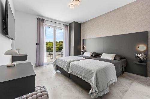 a bedroom with a large bed and a desk at Villa Delecto in Premantura