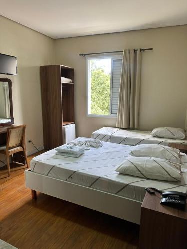 ein Schlafzimmer mit zwei Betten und einem Fenster in der Unterkunft Hotel Moraes próximo a 25 de Março, Brás e Bom Retiro - Reserve agora e só pague no check-in in São Paulo