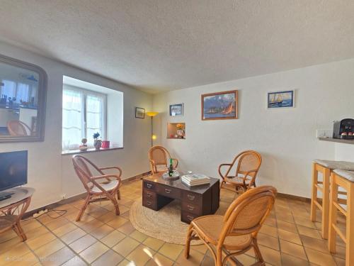 a living room with chairs and a table and a tv at Ty Coët, plage et Golfe à pieds in Arradon