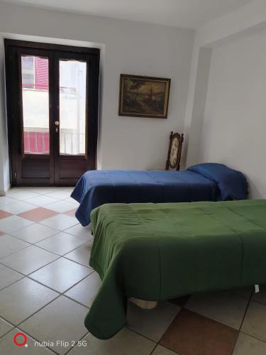 two beds with blue and green sheets in a room at Nonna Maria Bed and Breakfast in Caserta