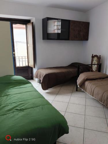 a bedroom with two beds and a tv on the wall at Nonna Maria Bed and Breakfast in Caserta