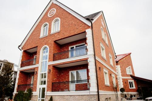a red brick building with white windows and balconies at Байків in Ternopil