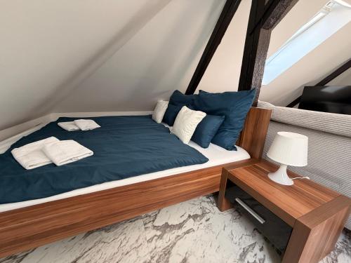 a bedroom with a bed with blue sheets and pillows at Loft Apartment with Parking in Poruba