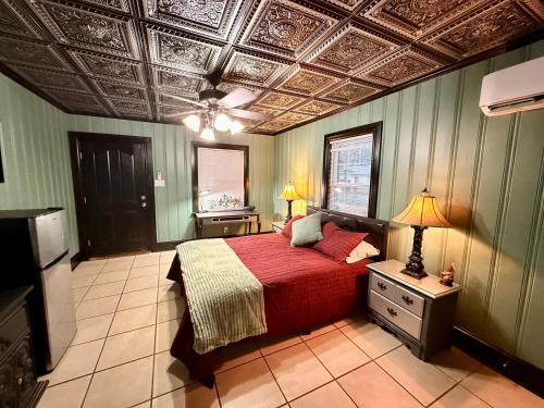 a bedroom with a bed with a red blanket and a ceiling at Historic Ziegler Inn and Suites with Whimsical Themed Rooms in New Bern