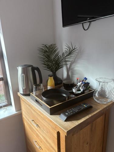 a wooden cabinet with a sink and a tv on it at The Three Horseshoes Boutique Rooms in Dunstall