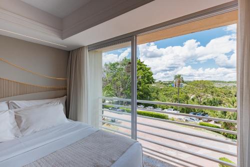 a bedroom with a bed and a large window at Rio Quente Resorts Refúgio Grand Premium - Antigo Hotel Turismo in Rio Quente