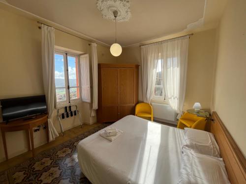 a bedroom with a white bed and a television at Hotel Liberty in Pattada