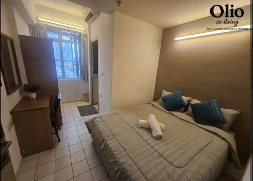 a bedroom with a bed with two towels on it at Olio CoLiving Pudu Kuala Lumpur in Kuala Lumpur