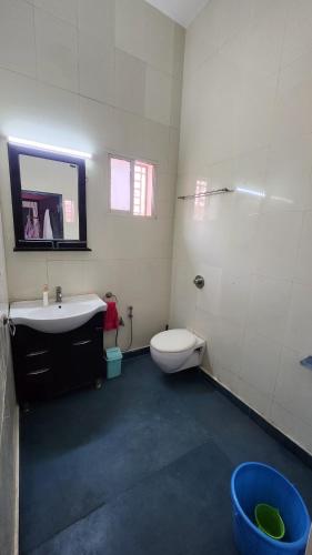 a bathroom with a toilet and a sink at The Travelers Nest Home Stay in Jhānsi