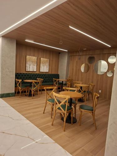 una sala da pranzo con tavoli e sedie in legno di HIMMA Hotel a Aparecida