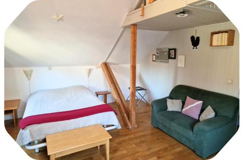 a bedroom with a bed and a green couch at Gîte 2 pers - La Pommeraie - Le Coin Ardenne in Sainte-Ode