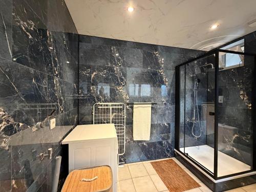 a bathroom with a black marble wall at Schorrebloem in Lombardsijde