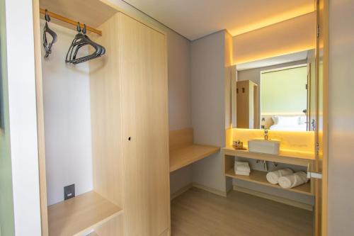 a bathroom with a sink and a mirror at Liwe Hotels in Penha