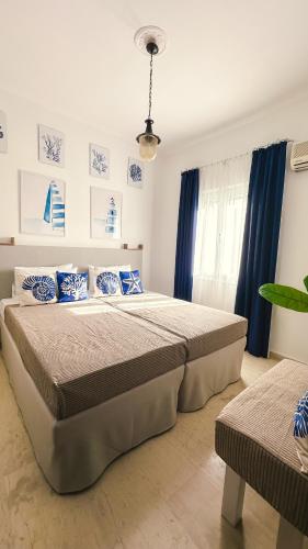 a bedroom with a large bed and blue curtains at Blue Pearl Molos in Mólos