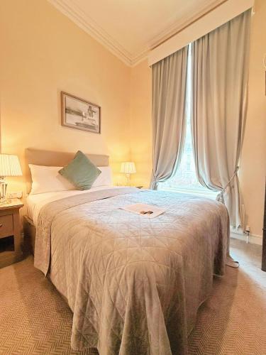 a bedroom with a large bed with a window at Waterloo Lodge in Dublin