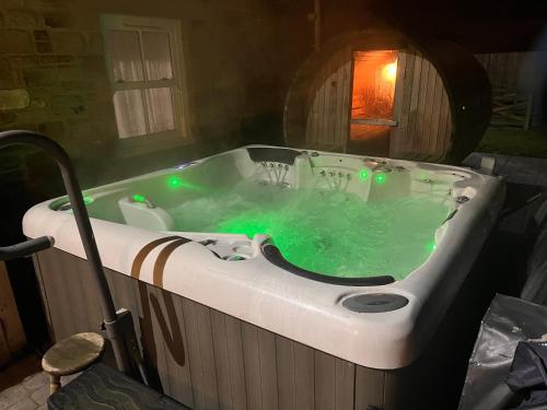 a bath tub filled with green water in a bathroom at Waterside Equestrian Lodge in Durham