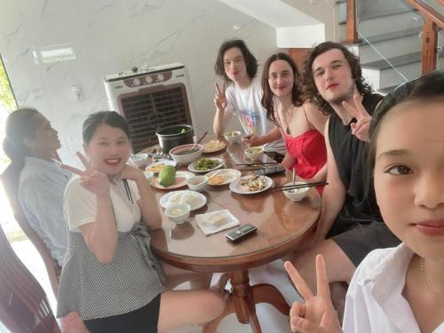 a group of girls sitting around a table at Memory Homestay Ông Chung in Lệ Thủy