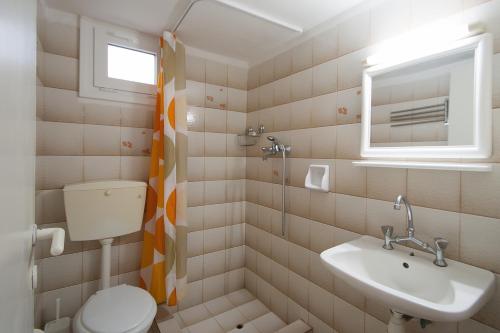 a bathroom with a toilet and a sink at Villa ALEXIS in Koukounaries