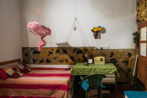 a room with a bed and a table with a phone at Kon Tree Shade in Dambulla