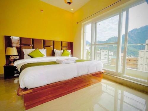 a bedroom with a large bed with a large window at Hotel Blue Moon in Rishīkesh