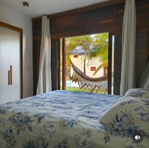a bedroom with a bed with a view of a hammock at Casa Sol e mar Uruaú in Beberibe