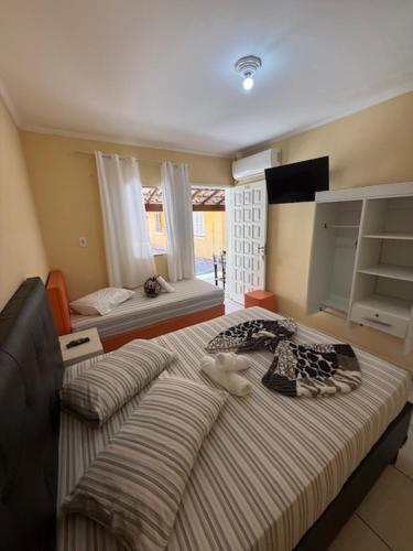 a bedroom with a large bed and a window at Hotel Leblon in Peruíbe