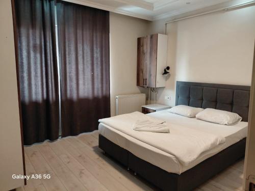 a bedroom with a large bed and a large window at Esta123 in Kavaklıdere